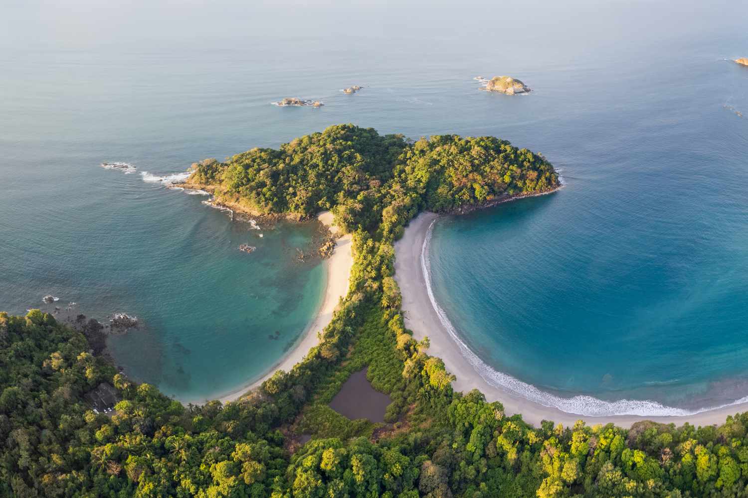 Vista aérea de la península de Manuel Antonio con playas de arena blanca, selva tropical y aguas turquesa del Pacífico
